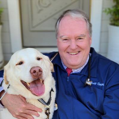 a person holding a dog posing for the camera