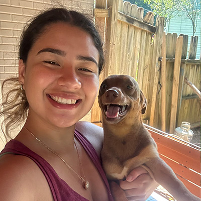 a woman holding a dog posing for the camera