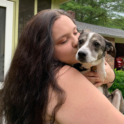 a woman sitting next to a dog