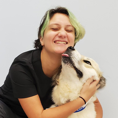 a woman holding a dog posing for the camera