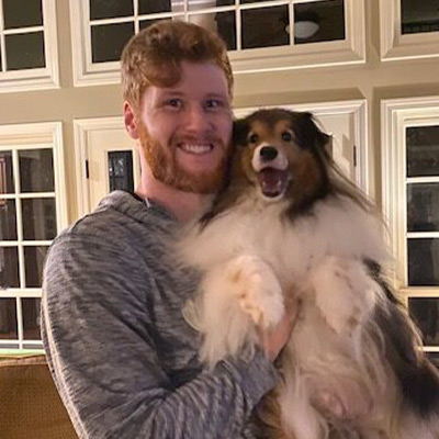 a person holding a dog posing for the camera