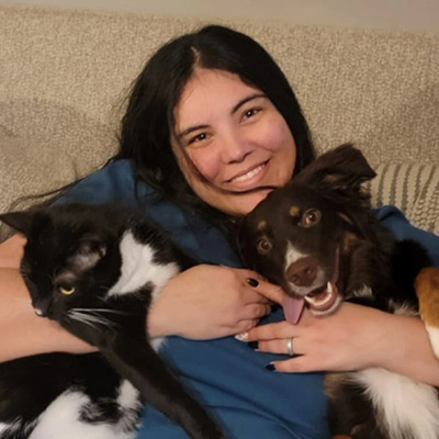 a person petting a cat and a dog