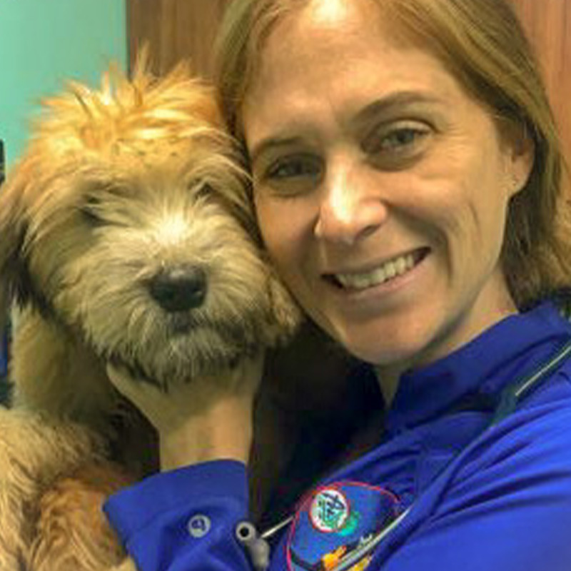 a person holding a dog posing for the camera