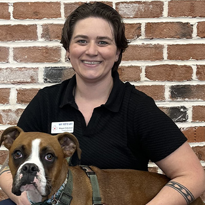 a person holding a dog posing for the camera