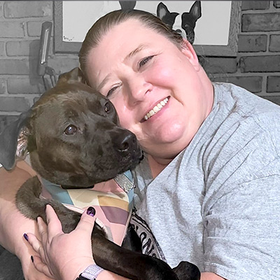 a person holding a dog posing for the camera