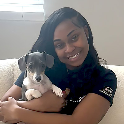 a woman holding a dog posing for the camera