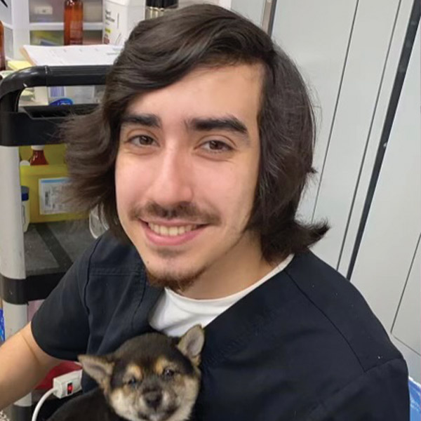 a woman holding a dog posing for the camera
